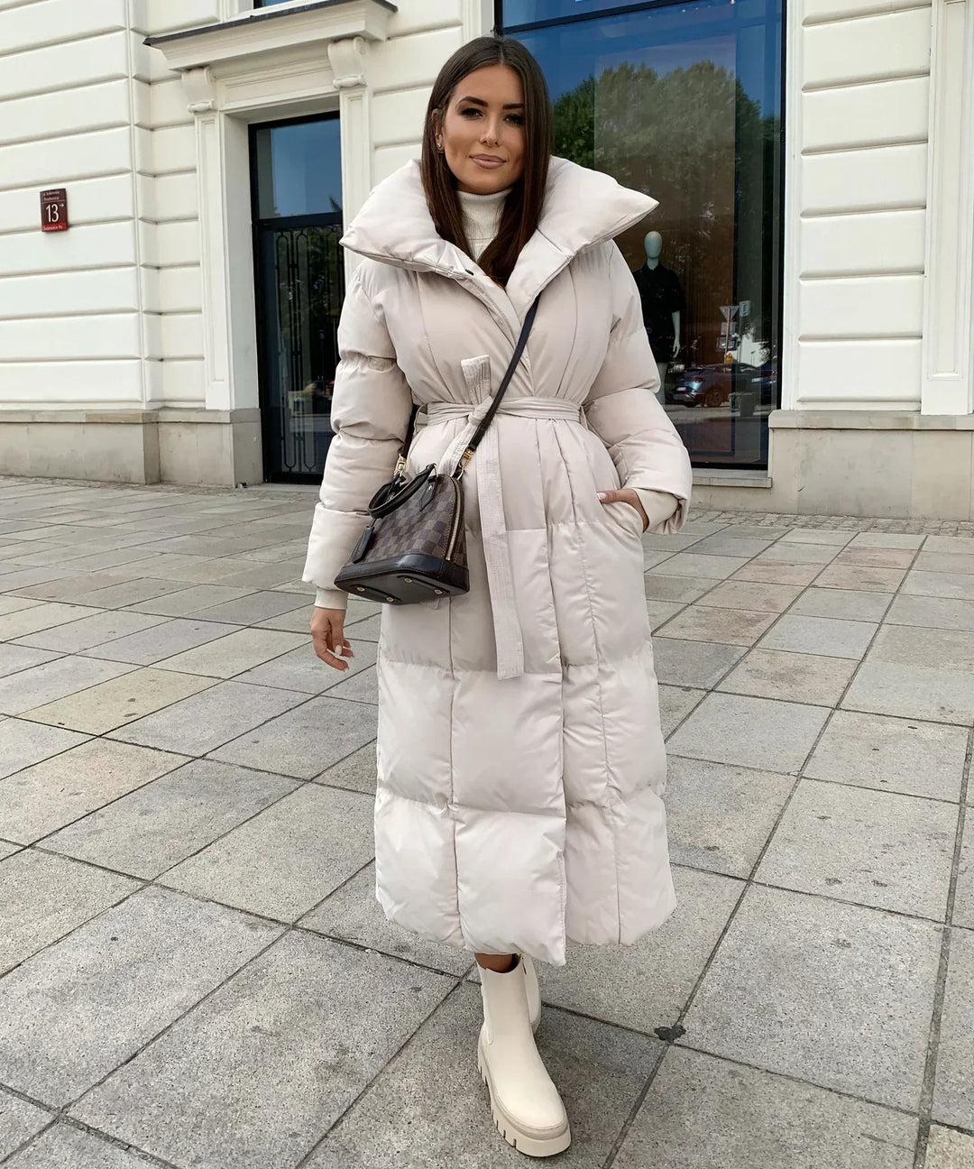 Lange Damenpufferjacke mit Gürtel und hohem Kragen