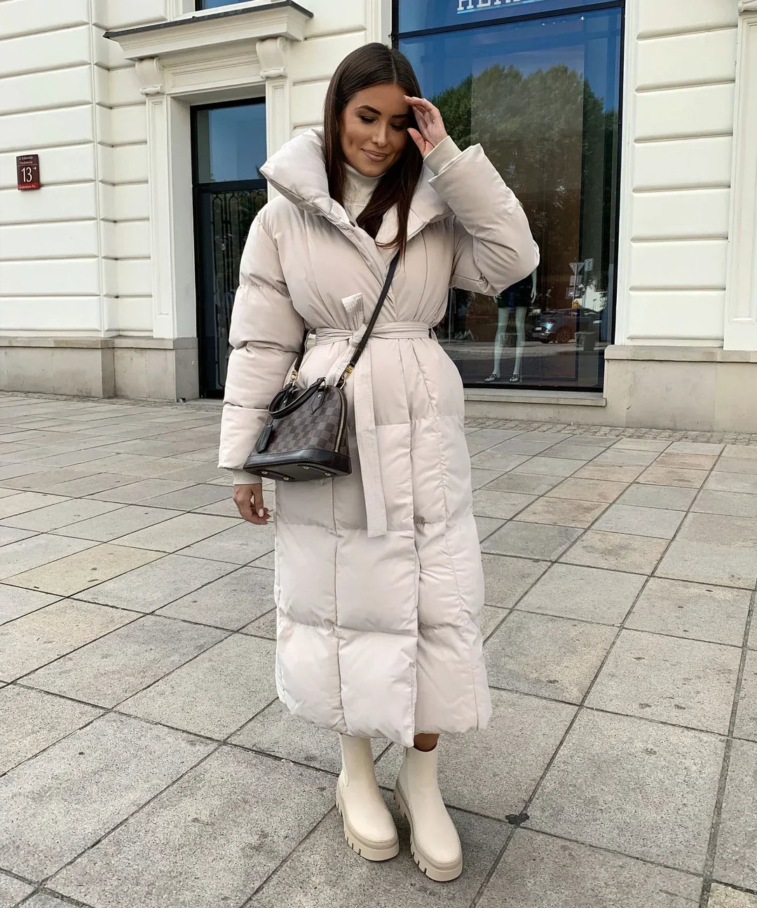 Lange Damenpufferjacke mit Gürtel und hohem Kragen